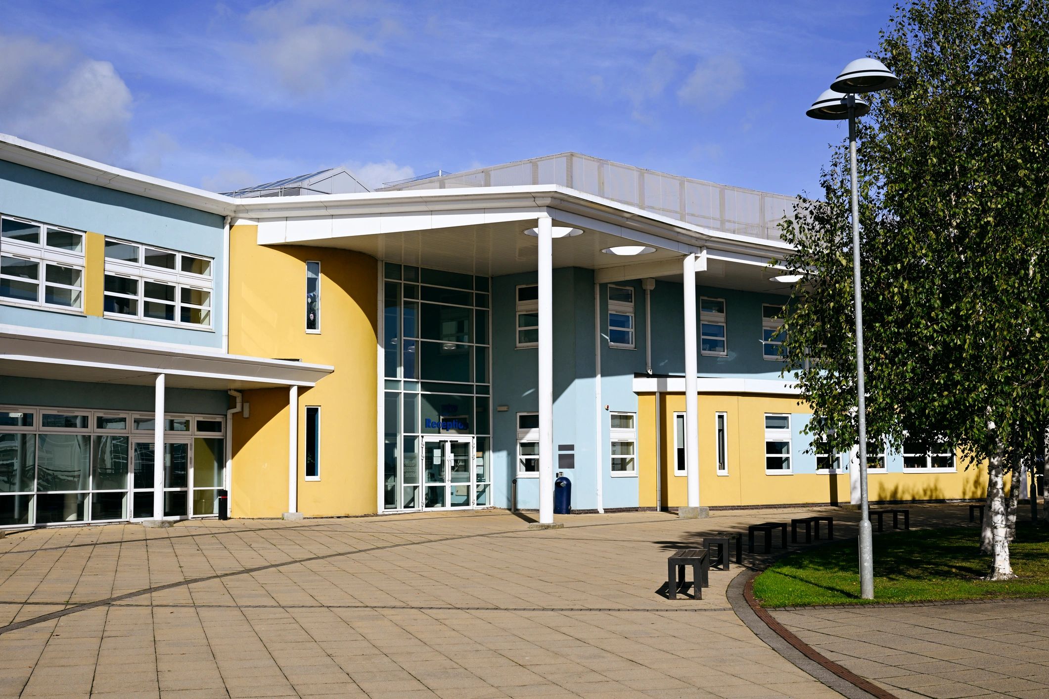 School building exterior with benches and walkway