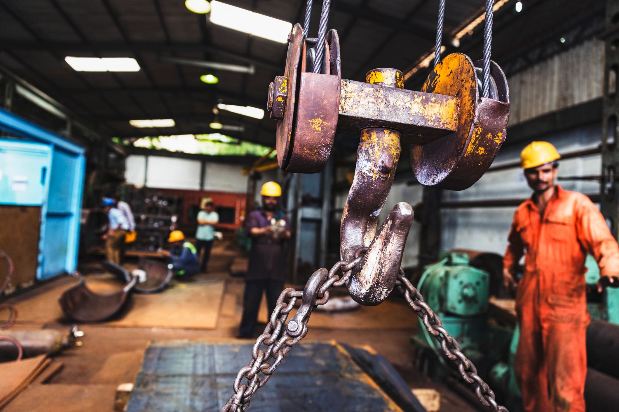 Crane lifting heavy metal sheets at an industrial site