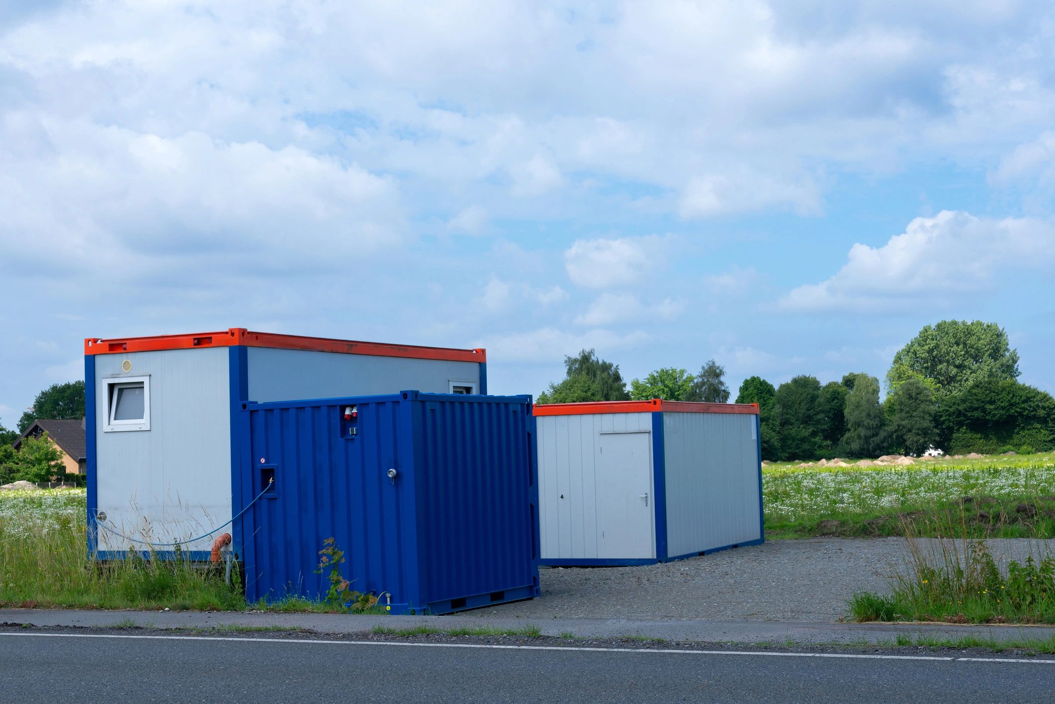 Single-story containerized modular housing units on a gravel lot